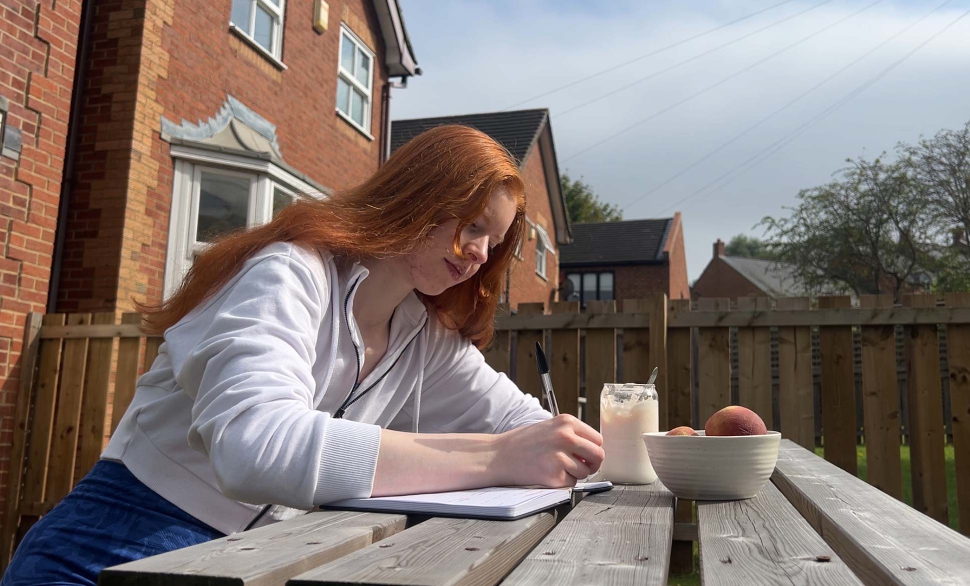 Coach writing down while sitting outside